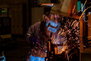 Welder is welding automotive part.
