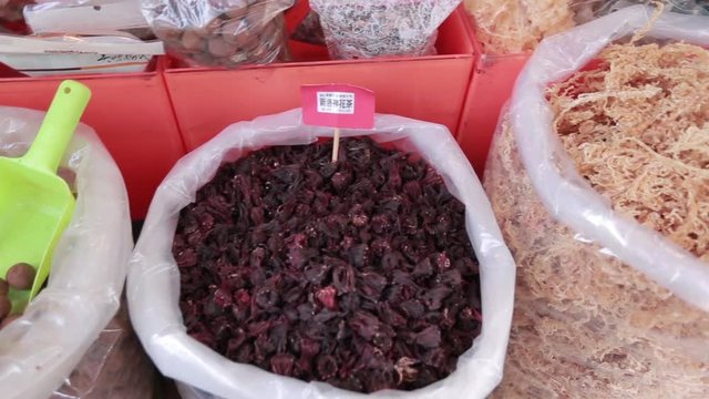 Sacks with dried red poppy flowers, nearby there are also various squid, dried fish and other foods. A marketplace in Dihua Street, a famous commercial place in Taipei, Taiwan.