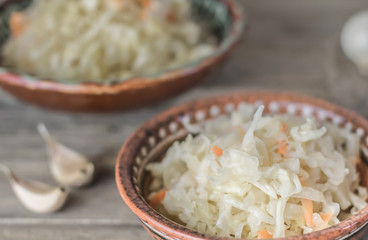 Homemade sauerkraut village. Fermented cabbage. Vegan salad rustic style glass jar or ceramic pottery bowl. Fermented food great for good health. Traditional rustic winter food.