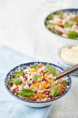 a bowl of rice salad with ham stripes, broken almonds, dried cranberries and orange
