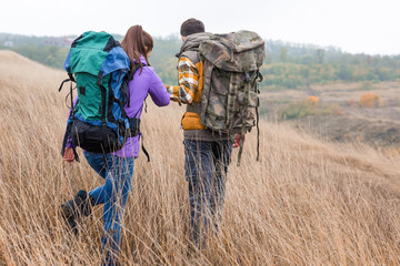 Obraz premium Young couple with backpacks walking in countryside