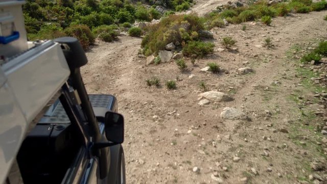 4k shot from a camera attached to the side of an off road campervan driving on rough tracks in sardinia, italy