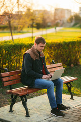 Fototapeta premium The young manager working on a laptop in the park. Lunch Break.