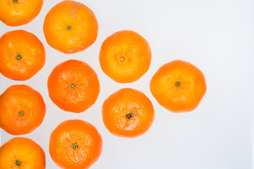 High angle view of a pyramid of whole ripe mandarins on white background