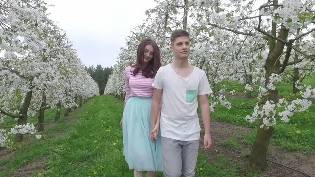 Junges verliebtes Paar im Kirschbl&uuml;tenfeld