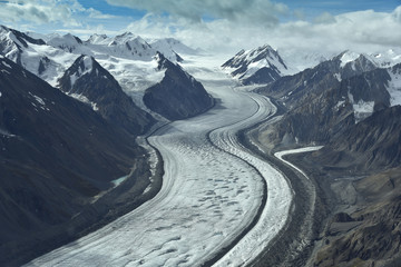 aerial photo of a glacier between mountains in alaska