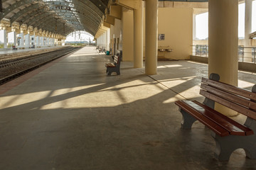 Wide view of a locomotive electric train station platform with unoccupied seat and covered tunnel, Chennai, India, Mar 29 2017