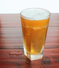 A glass of Lager beer stands on the table flip-top bottle
