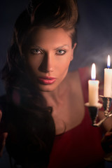 Beautiful woman in the dark room with a lot of candles