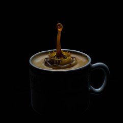 Splash of coffee and milk in white cup