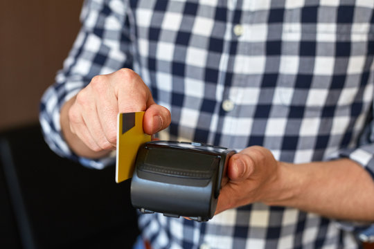 Male hands using payment terminal paying with credit card, finance concept