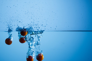 Cerezas lanzadas al agua y tomadas a alta velocidad