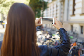 frau macht ein foto mit ihrem handy in der stadt