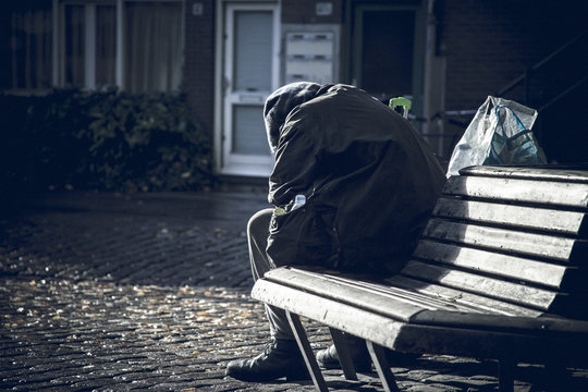 Einsamer Mann sitzt traurig auf einer Bank.