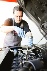 Fototapeta na wymiar Auto mechanic repairing car. Selective focus.