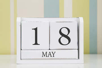 Cube shape calendar for MAY 18 on white table. 