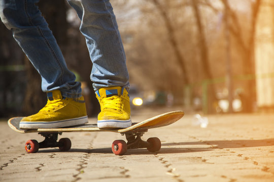 young skateboarder legs skateboarding at skatepark
