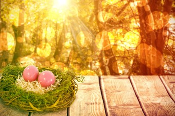 Composite image of pink easter eggs on artificial nest