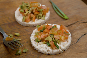 Rice cookies with vegetables. Vegan snacks. Snacks from rice cookies, tomatoes, avocado on cutting board.