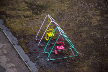 Swings stand in a water after rain in the spring