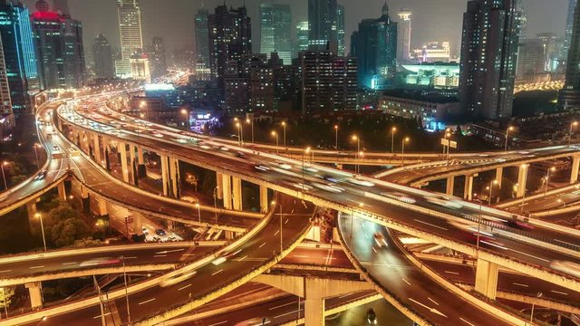 Complex highways in Shanghai, China, at night. Scenic aerial view of big illuminated interchange with fast moving cars. 4K Time lapse. 