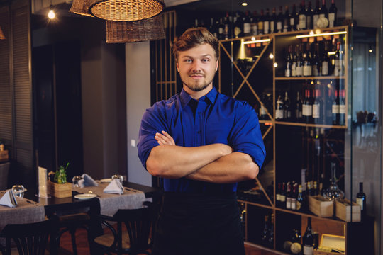 Cheerful waiter in modern restaurant