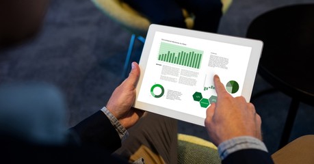 Businessman analyzing graphs on digital tablet