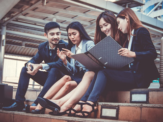 Group of office workers  colleagues discussing and sitting outside office. Business and lifestyle concept.