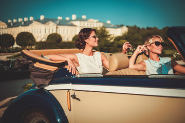Two stylish ladies in a classic convertible