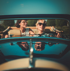 Two stylish ladies in a classic convertible