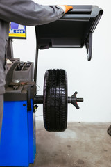 Fototapeta premium Auto mechanic repairing car. Selective focus on wheel.