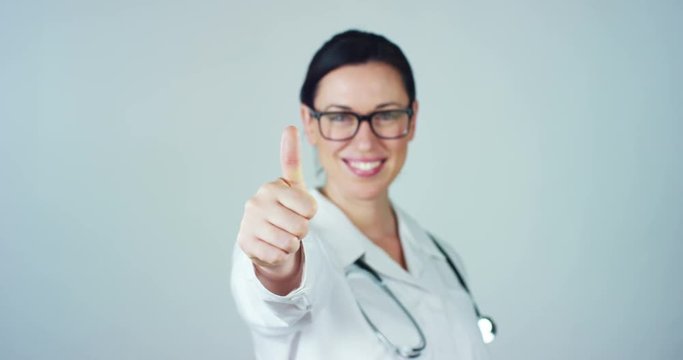 Portrait of a female doctor with white coat and stethoscope smiling looking into camera on white background. Concept: doctor, health care, love of medicine.