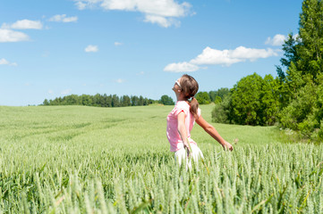 Enjoying the summer! Young happy girl inbreathing soft summer wind