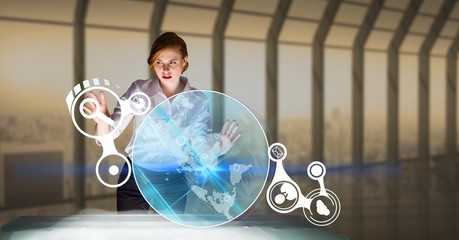 Businesswoman touching icons at futuristic desk in office