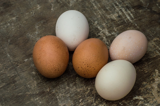 Five fresh chicken eggs on an old wooden background