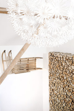 Old refurbished wooden chalet and woodshed, old sleds and a white design lamp