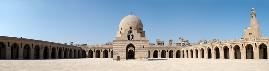 Fototapeta na wymiar Panorama of the courtyard of Ibn Tulun Mosque, Cairo, Egypt, featuring the ablution fountain and the minaret. The largest one in Cairo, and the oldest one in the city with its original form