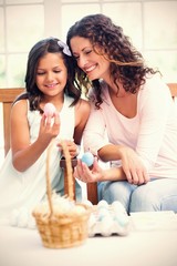 Happy mother and daughter holding easter eggs 