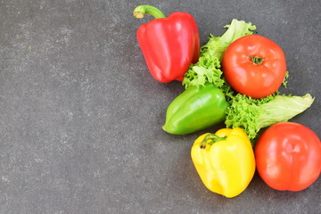 Fresh vegatables: paprika, tomato, onion,onion, carrot on a rustic textile cloth on a grey wooden background. Healthy eating concept. Place for text.