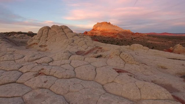 Rising view of desert terrain with drone at sunrise