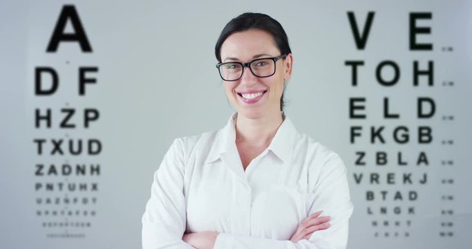 Portrait of a female doctor with white coat and stethoscope smiling looking into camera on white background, diopters lacking in his eyes for a perfect view. Glasses concept, view, eye examination