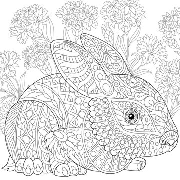 Stylized rabbit (bunny, hare) and cornflowers. Freehand sketch for adult anti stress coloring book page with doodle and zentangle elements.