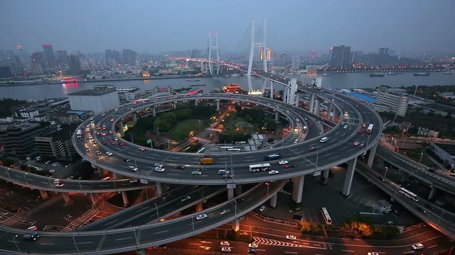 View over the famous highway intersection in Shanghai, China, with traffic. Shanghai skyline by night.