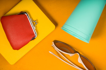 Wallet on a notepad, glasses, glass on a yellow pop art background