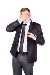 portrait young businessman covering his eyes with his hand. emotions, facial expressions, feelings, body language, signs. image on a white studio background.