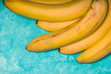 Whole bananas on a turquoise background free space
