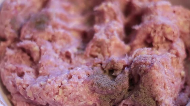Putting minced meat and vegetable mixture through mincer at home at home