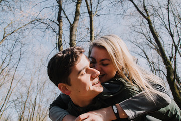 Cheerful loving each other couple kisses. Walk in the park and hug.