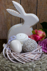 Easter eggs hunt - Bunny with nest of white eggs and roses