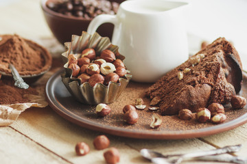 Piece of chocolate cake, hazelnuts and jar with milk